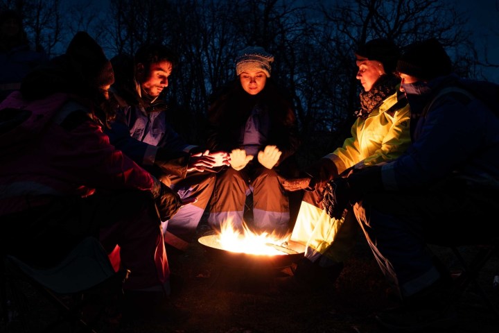 a group of people sitting around a fire